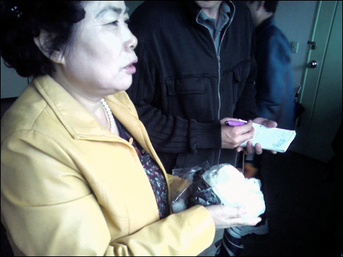 20일 무죄를 선고받은 미네르바 박대성씨의 어머니가 서울 구치소에서 두부를 들고 아들이 무죄 방면되기를 기다리고 있다(이 사진은 #5505 엄지뉴스로 1549님이 보내주셨습니다). 