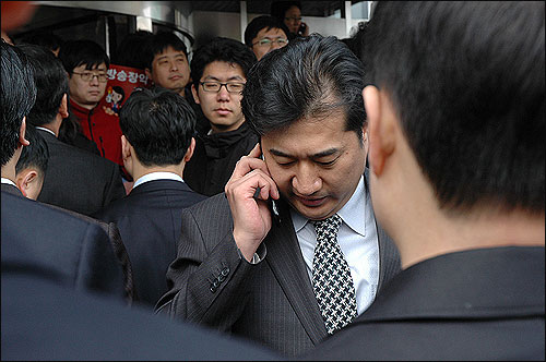 박길배 검사가 언론노조 MBC 본부 조합원들과 대치하던 중 어디론가에서 걸려온 전화를 받고 있다.
