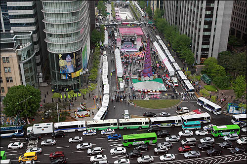 2009년 5월 2일 미국산 쇠고기 수입 반대 촛불시위 1주년 기념 행사가 예정돼있는 서울 청계광장 주변을 경찰이 차량으로 에워싸 원천봉쇄하고 있다. 광장 중앙에서는 서울시에서 주최하는 하이서울 페스티벌 행사가 진행중이다.