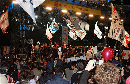 미국산 쇠고기 수입 반대 촛불시위 1주년을 맞아 촛불시민들이 2일 저녁 서울 세종로 일대에서 시위를 벌이다 경찰에 가로막히자 서울광장에서 열리고 있는 '2009 하이서울 페스티벌' 행사 무대를 점거하고 있다. 