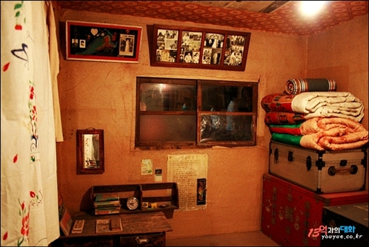 수도국산달동네박물관에 전시된 방안 모습. 벽에 걸린 액자에는 가족사진들이 걸려 있다.