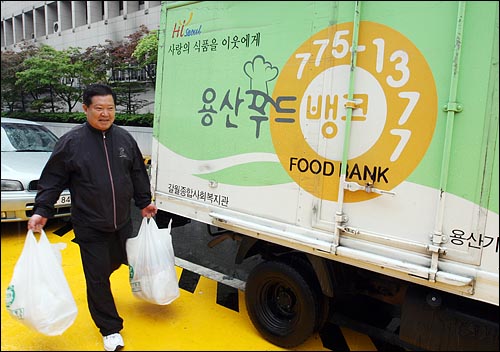  용산구 푸드뱅크 직원 이응고씨가 12일 오전 서울 중구 파리크라상 서울역점에서 기부 받은 빵을 차에 싣고 있다.