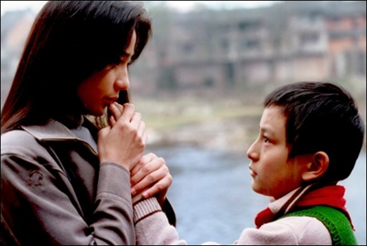 영화 <홍옌>의 한 장면. 낙인으로 살아오던 마을 떠나기 전에 아들임을 알게 된 샤오융에게 자신과 닮았다는 것을 알려주려고 손을 눈, 코, 입술, 이마에 가져가고 있는 슬픈 장면이다.