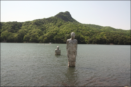 명성산 맞은편 망루봉과 호수 물속에 세워져 있는 조각 작품들