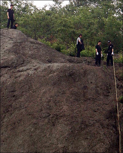 23일 오후 봉화산 부엉이 바위에서 경찰들이 현장검증을 하고 있다.