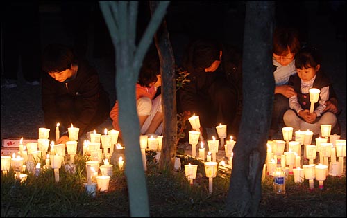 노무현 전 대통령이 서거한 23일 저녁 경남 김해시 봉하마을에 마련된 임시분향소에서 시민들이 촛불을 밝히며 애도의 뜻을 표하고 있다.
