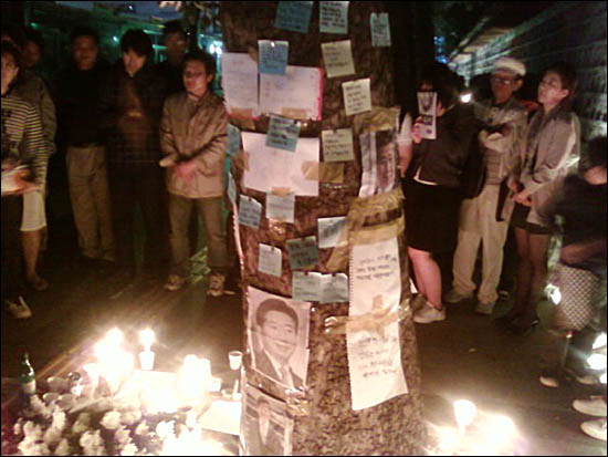  시청역 출구 느티나무에 촛불과 국화와 함께 붙여진 '노무현 대통령님 안녕히 가세요' 편지들. 추모 행렬이 수십미터 이어지고 있다 