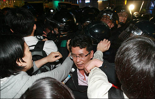 23일 밤 서울 덕수궁 대한문 앞에 마련된 노무현 전 대통령 임시 분향소를 찾은 추모행렬이 분향소를 에워싼 경찰에 항의하며 몸싸움을 벌이고 있다.
