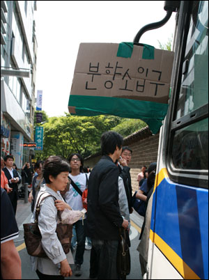 노무현 전 대통령 서거 다음날인 24일 서울 덕수궁 대한문 앞에 차려진 시민 분향소가 경찰버스로 둘러싸인 가운데 시민들이 종이 박스로 안내판을 만들어 경찰버스 백미러에 달았다.