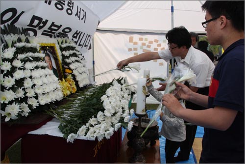  흰백합화를 준비해 와 노무현 전 대통령의 영정 앞에 헌화하고 있는 류정아(43)씨 가족.