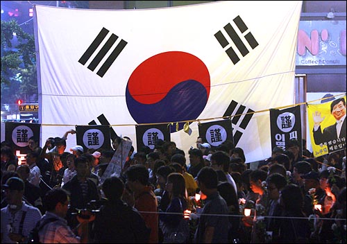 24일 밤 고 노무현 전 대통령 분향소가 마련된 서울 덕수궁앞에 국화꽃과 촛불을 든 시민들이조문 순서를 기다리고 있다.