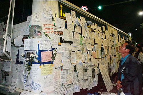 24일 밤 서울 덕수궁 대한문 앞에 마련된 노무현 전 대통령의 분향소를 켭켭이 둘러싼 경찰 차벽에 조문객들이 남긴 추모의 글이 빼곡히 붙어 있다.