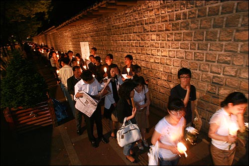 26일 밤 서울 덕수궁 앞에 마련된 고 노무현 전 대통령 분향소에 조문하기 위해 촛불을 든 시민들이 돌담길을 따라 수백 미터씩 줄을 서서 기다리고 있다.