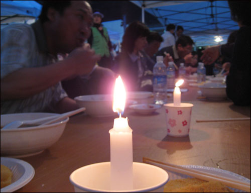 26일 경남 김해 봉하마을 노무현 전 대통령 빈소 앞에서 촛불을 켜 놓은 채 저녁 식사를 하는 조문객들.