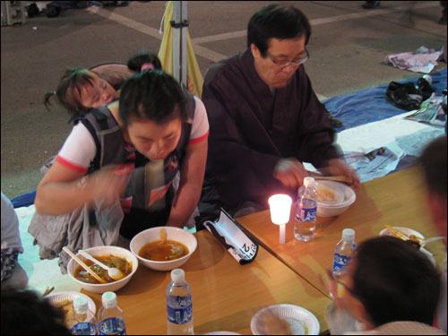 26일 경남 김해 봉하마을 노무현 전 대통령 빈소 앞에서 촛불을 켜 놓은 채 저녁 식사를 하는 조문객들.