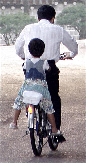 [미공개 사진] 휴일을 맞아 청와대에서 손녀와 자전거를 타고 있는 노무현 대통령. 손녀의 엉덩이가 아플까봐 안장에는 수건이 깔려 있다. (2007.9.13) 