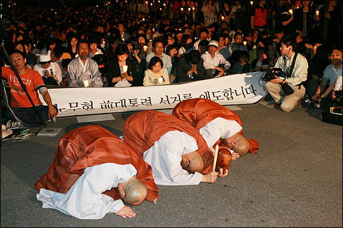 정부가 고 노무현 전 대통령 추모행사 장소로 서울광장 사용을 불허한 가운데 27일 저녁 서울 정동 로타리에서 열린 노 전 대통령 추모행사에 참석한 스님들이 참회의 절을 올리고 있다.