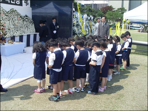 원복을 맞춰 입은 유치원 아이들이 故노무현 대통령을 위해 묵념하고 있다