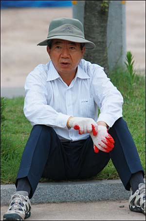 2008년 7월 7일. 비서진들과 마을 청소를 하기 위해 목장갑을 끼며 일할 채비를 하는 대통령님