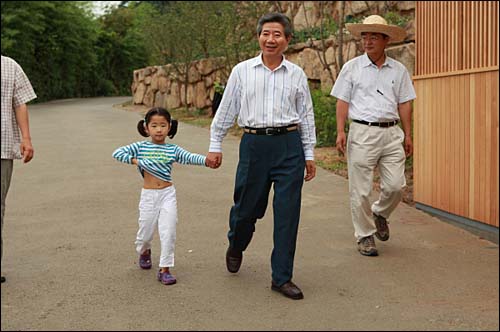 2008년 8월 16일. 사저 옆 잔디밭으로 자원봉사자들을 만나기 위해 손녀 서은양과 같이 정답게 걸어가고 계시는 대통령님. 서은양의 모습이 천진난만하기만 하다.