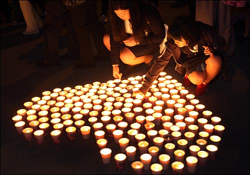 노무현 전 대통령의 유골함이 정토원에 도착할 예정인 가운데 29일 밤 경남 김해 봉하마을 노 전 대통령 사저 앞에서 추모객들이 촛불로 하트 모양을 만들고 있다.