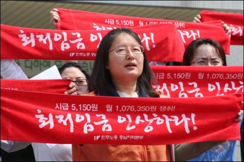 6월 2일 민주노총 충남지역본부와 충남최저임금연대 기자회견 참가자들이 '최저임금 인상하라!'고 쓴 손 현수막을 펼치고 있다.