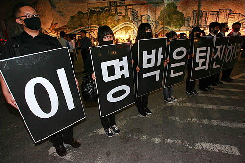 6·10 민주항쟁 22주년을 맞은 10일 저녁 서울광장에서 열린 '6월항쟁 계승·민주회복을 위한 범국민대회' 참가자들이 이명박 대통령 퇴진을 요구하는 피켓을 들고 있다.