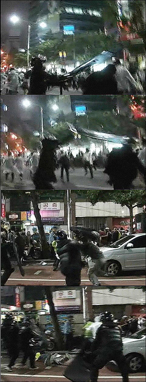 경찰이 6.10 범국민대회에 참가한 시민들에 대한 해산작전을 펼치면서  방패로 달려가는 시민의 머리와 목을 가격하고 있다.