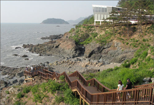 나무계단을 따라 바닷가까지 내려가볼 수 있는 것은 백수해안도로의 장점이다. 오른쪽 위에 보이는 건물은 노을전시관이다.