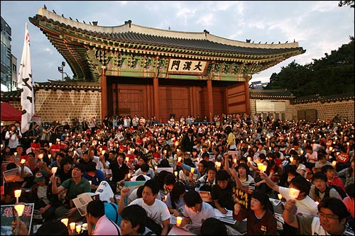 13일 오후 서울 덕수궁 대한문앞에서 열린 6.10 범국민대회 폭력진압 규탄 촛불문화제에서 참가자들이 이명박 정권을 규탄하는 손피켓과 촛불을 흔들며 구호를 외치고 있다.