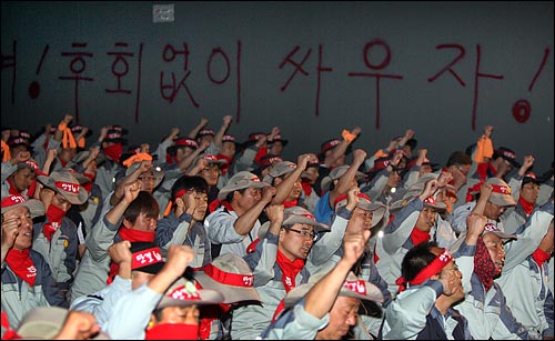  15일 저녁 경기 평택시 칠괴동 쌍용자동차 공장에서 정리해고에 반대하며 공장 점거파업을 벌이고 있는 쌍용자동차 노조원들이 쌍용차 대량 해고 문제 해결 등을 요구하며 구호를 외치고 있다.