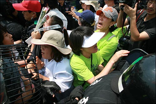 지난 2009년 6월 옥쇄파업 당시 쌍용자동차 노동자 가족들이 '점거농성 중단'을 요구하며 시위를 벌이는 사측 직원들에게 항의를 하다 경찰에 둘러싸여 울부짖고 있다.