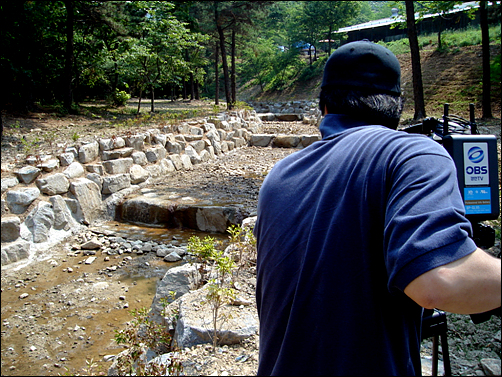 계곡 주변을 콘크리트와 바윗돌로 덮은 현장을 촬영중이다.