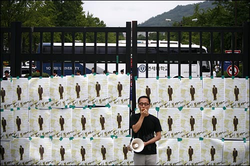 오는 21일 연세대 총학생회가 주최하는 '고 노무현 전 대통령 추모콘서트 - 다시 바람이분다'를 19일 연세대 학교측이 갑자기 불허하고 행사준비 차량을 막기위해 교문을 봉쇄한 가운데 학생들이 닫힌 교문앞에서 추모콘서트 허가를 요구하고 있다. 닫힌 교문안쪽에는 스쿨버스로 '차벽'을 설치했다.