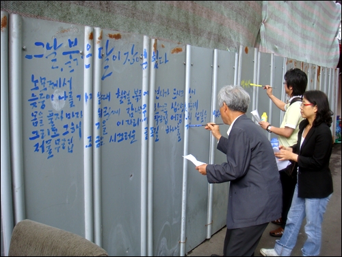6월10일 용산을 찾은 작가들이 참사현장에 벽시를 쓰고 있다. 