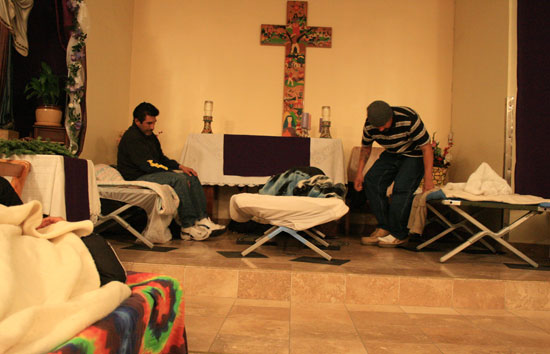 십자가 아래 강대상에 잠자리를 마련한 노숙자들.