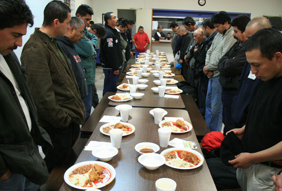 식사 기도를 하고 있는 노숙자들. 노숙자들의 식사는 지역사회에서 기부한 것이다.