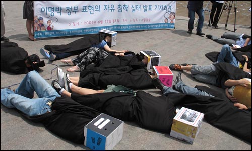 22일 오전 11시 서울광장에서 열린 '이명박 정부 표현의 자유 침해 실태 발표 기자회견'에서 참가자들이 정부 탄압에 쓰러진 모습의 퍼포먼스를 하고 있다.
