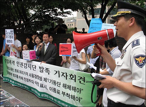 22일 오후 1시 서울경찰청 제1기동당 앞에서 열린 '경찰폭력 인권감시단' 발족 기자회견장에 나타난 경찰이 해산경고방송을 하고 있다.