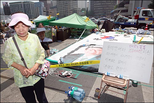  24일 오전 서울 덕수궁 대한문 앞 고 노무현 전대통령 시민분향소가 국민행동본부, 고엽제전우회 등 보수단체 회원들에 의해 기습 철거된 뒤 어지럽게 흐트러져 있는 현장을 본 한 시민이 허탈한 표정으로 돌아나서고 있다.