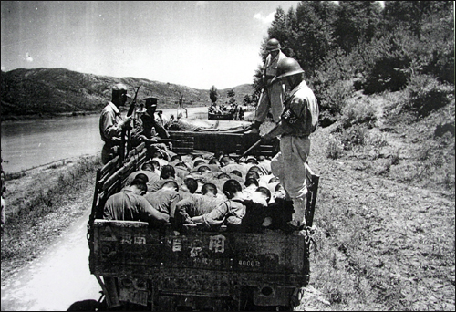  1950년 당시 암매장지로 끌려가고 있는 학살직전 사진. 오른쪽 뒷쪽 헌병과 공주형무소 특경대원(오른쪽 앞쪽), 경찰로 보이는(왼쪽 앞쪽) 사람들이  총을 들고 사람들을 감시하고 있다. 이 사진은 당시 영국 사진기자가 촬영한 것이다.  