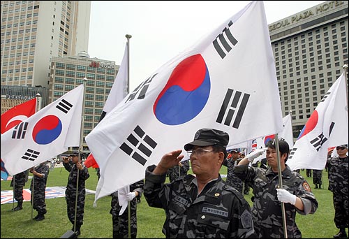 2009년 '6.25 전쟁 59주년 기념식'에서 대한민국특수임무수행자회 회원들이 국기에 대한 경례를 하고 있다.