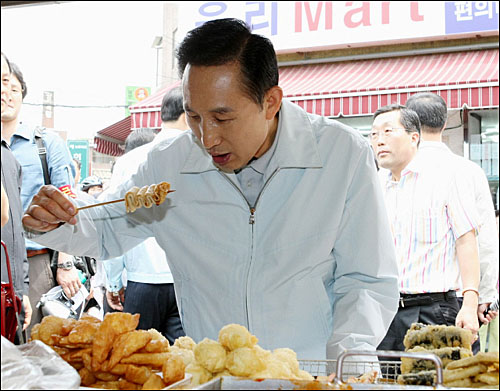 이 대통령은 25일 서울 이문동 재래시장 골목을 찾아 떡볶이와 어묵을 먹으며 시장상인들을 격려했다.