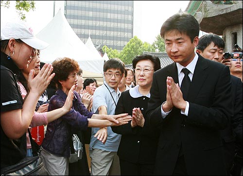 26일 오후 서울 조계사에서 열린 '고 노무현 전 대통령 5재'에 참석한 고인의 아들 노건호씨와 한명숙 전 총리에게 시민들이 '노무현' '힘내세요'를 외치며 격려의 박수를 보내고 있다.