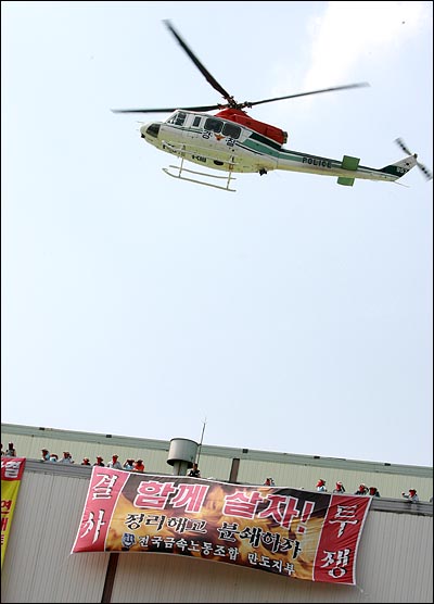 경찰헬기가 노동자들이 점거농성중인 쌍용차 도장공장 상공을 선회하고 있다.