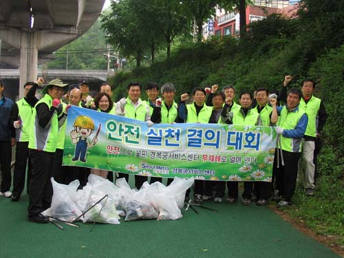  3호선 경복궁서비스센터 소속 역무원들이 봉사활동을 하고 안전결의대회 현수막을 펼쳐들었다. 
