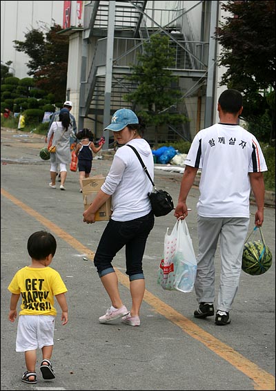  27일 밤 '정리해고'에 반대하며 경기도 평택 쌍용자동차 공장을 점거농성중인 노조원들과 대치하던 사측 직원, 용역, 경찰이  갑자기 철수한 가운데 28일 오전 출입이 자유로워진 공장으로 수박 등 음식을 챙겨온 가족들이 들어가고 있다.