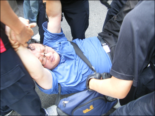 한 교직원이 경찰에 의해 연행되고 있다.