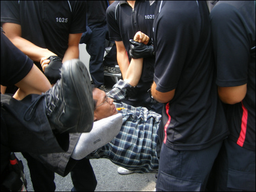 한 교직원이 경찰에 의해 연행되고 있다.