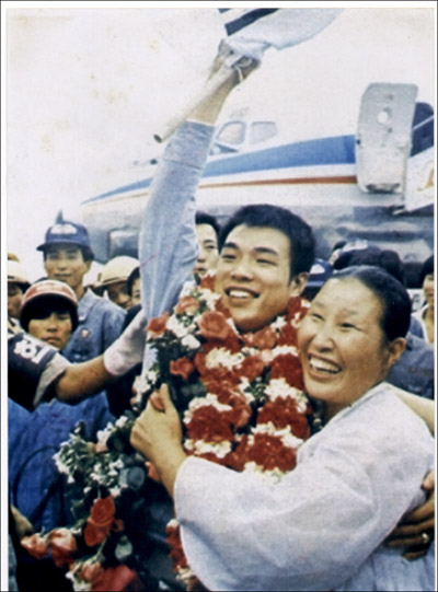  1974년 챔피언에 오른 홍수환이 귀국 직후 환영객들에게 손을 흔들고 있다. 어머니와 함께 찍은 이 사진은 최초 공개되는 사진이다. 